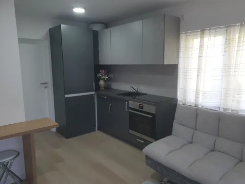 Manja kuhinja sa tamnim elementima i trpezarijskim delom u stanu. - image 8