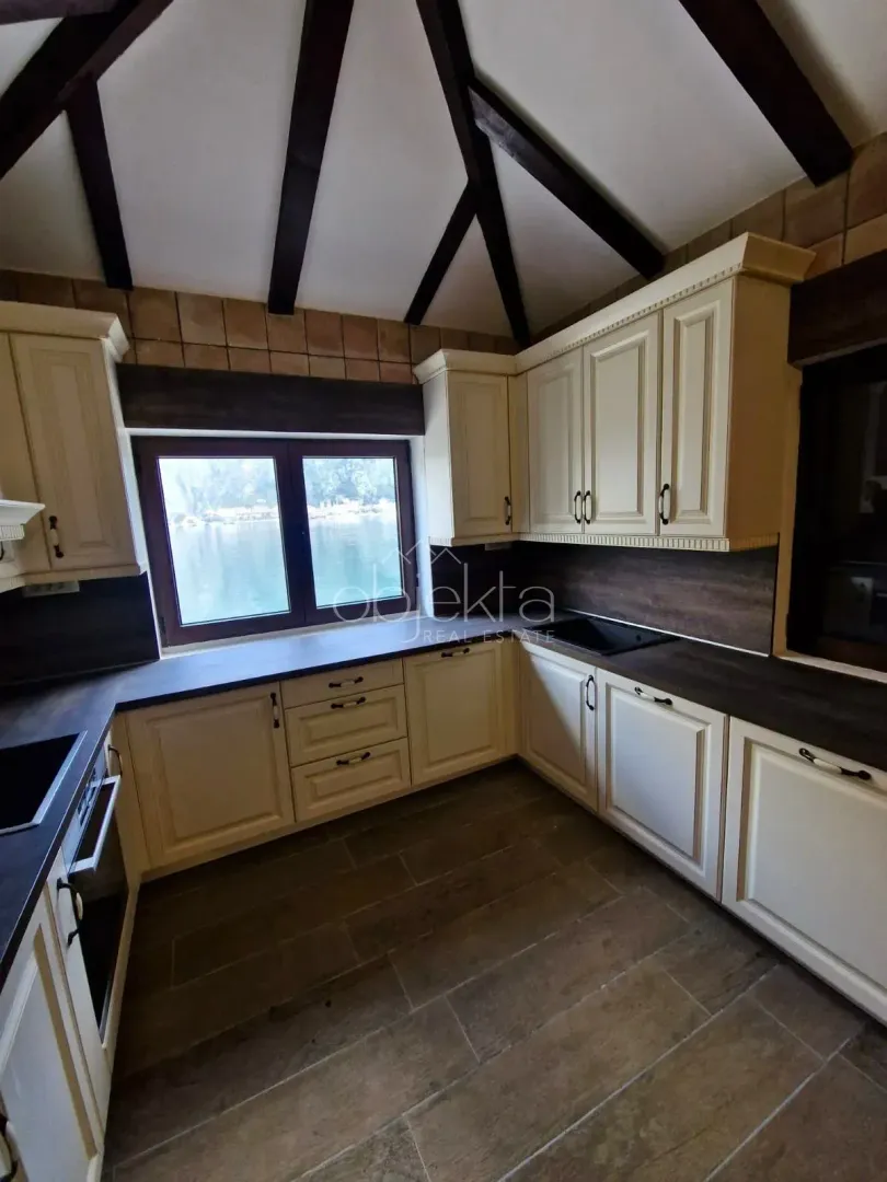 Rustic style kitchen with exposed wooden ceiling beams and a sea view.