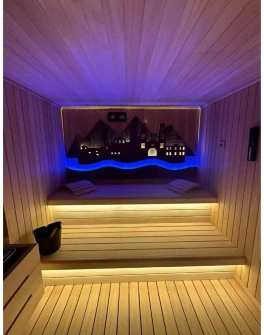 Modern wooden sauna with lighting and a decorative wall panel.
