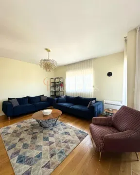 Prostrana dnevna soba sa garniturom za sjedenje i drvenim podom. - image 9