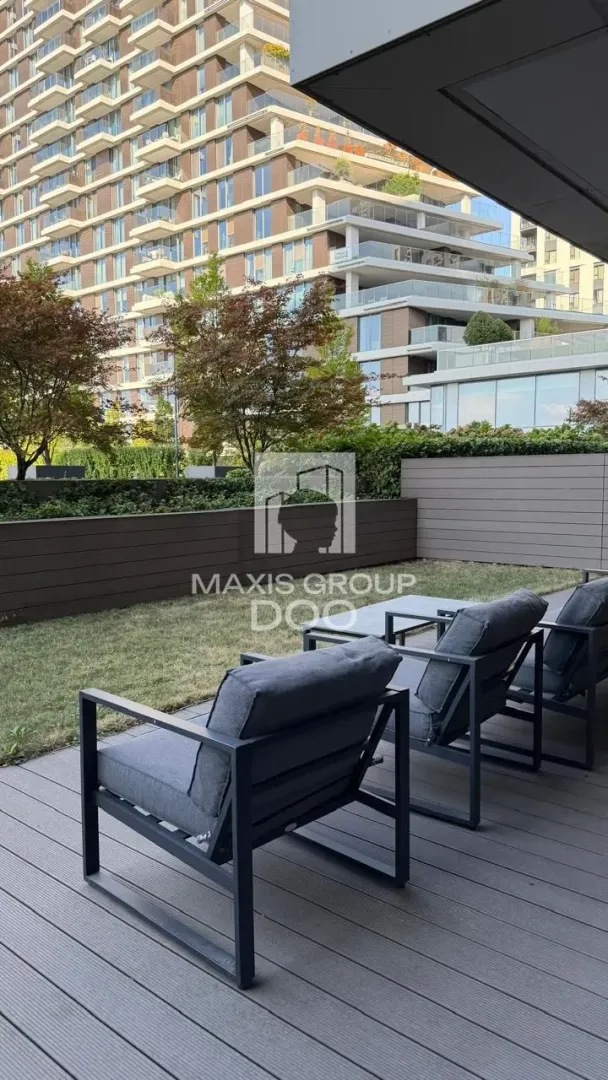Terrace with seating furniture and a view of the building and greenery.