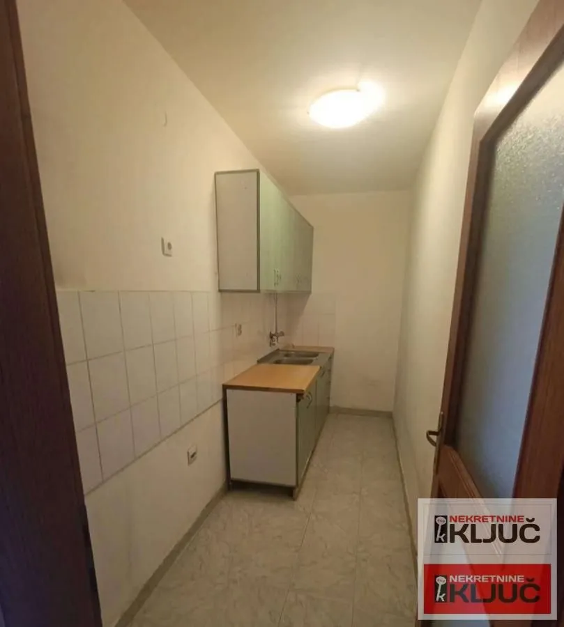 Manja kuhinja sa osnovnim elementima i sudoperom.