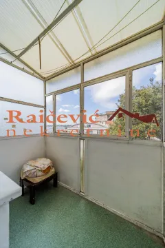 Zastakljeni balkon sa pogledom na okolne zgrade i nebo. - image 4