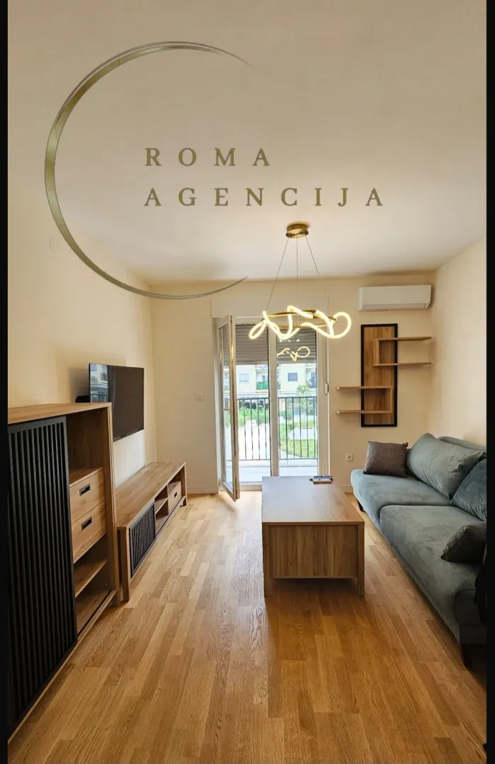 Living room with a sofa, wooden furniture, and access to the terrace.