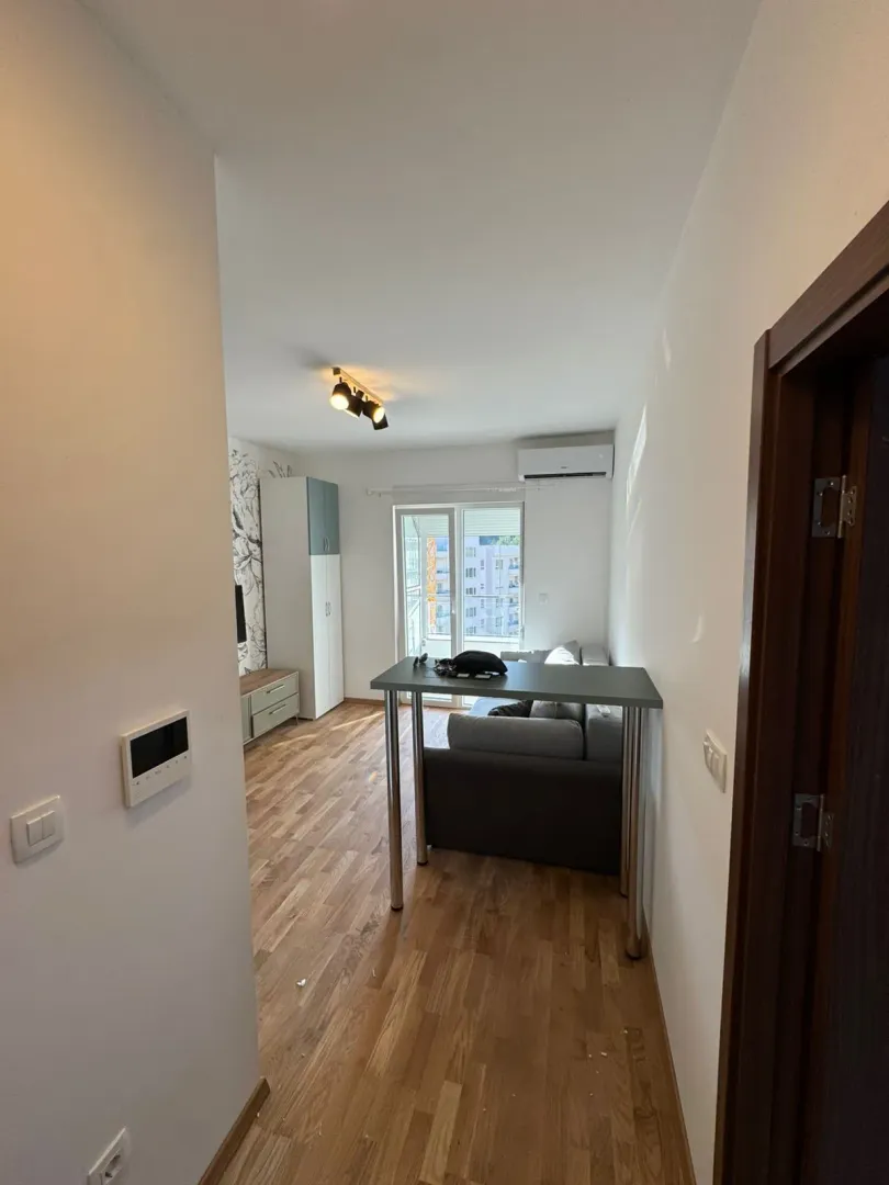 View from the hallway into the living room with a sofa and dining table.