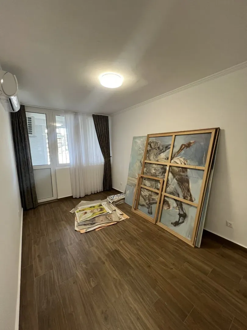 Bright empty room with art paintings leaning against the wall.