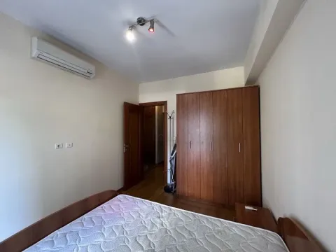 Namještena spavaća soba sa bračnim krevetom, velikim drvenim ormarom i klima uređajem. - image 5