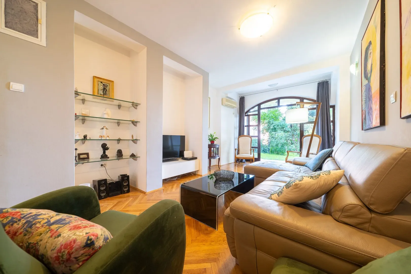 Bright living room with a leather sofa and access to the yard.