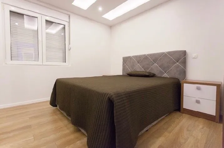 Bright bedroom with a double bed and nightstands.