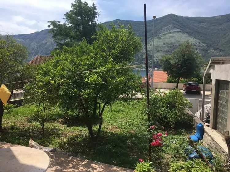 Dvorište sa zelenilom i pogledom na brda u daljini.