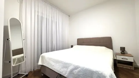 Bright and tidy bedroom with a double bed, nightstand, and mirror. - image 7