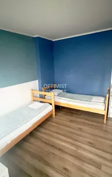 Spavaća soba sa dva drvena kreveta i plavim zidovima. - image 11