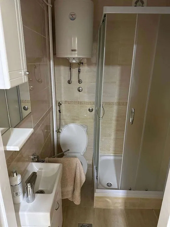 Manje kupatilo sa tuš kabinom, umivaonikom i wc šoljom.