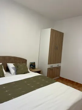 Furnished bedroom with a double bed and a wardrobe. - image 3