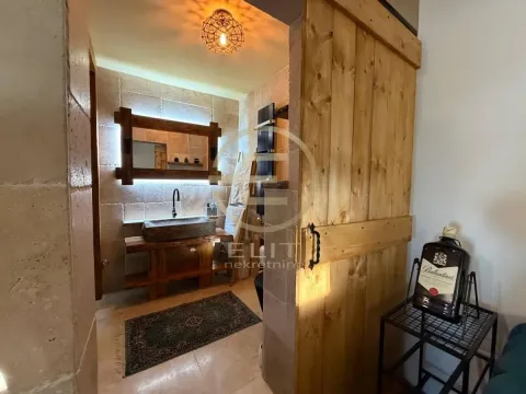 Kupatilo sa rustičnim drvenim elementima i kamenim umivaonikom. - image 49