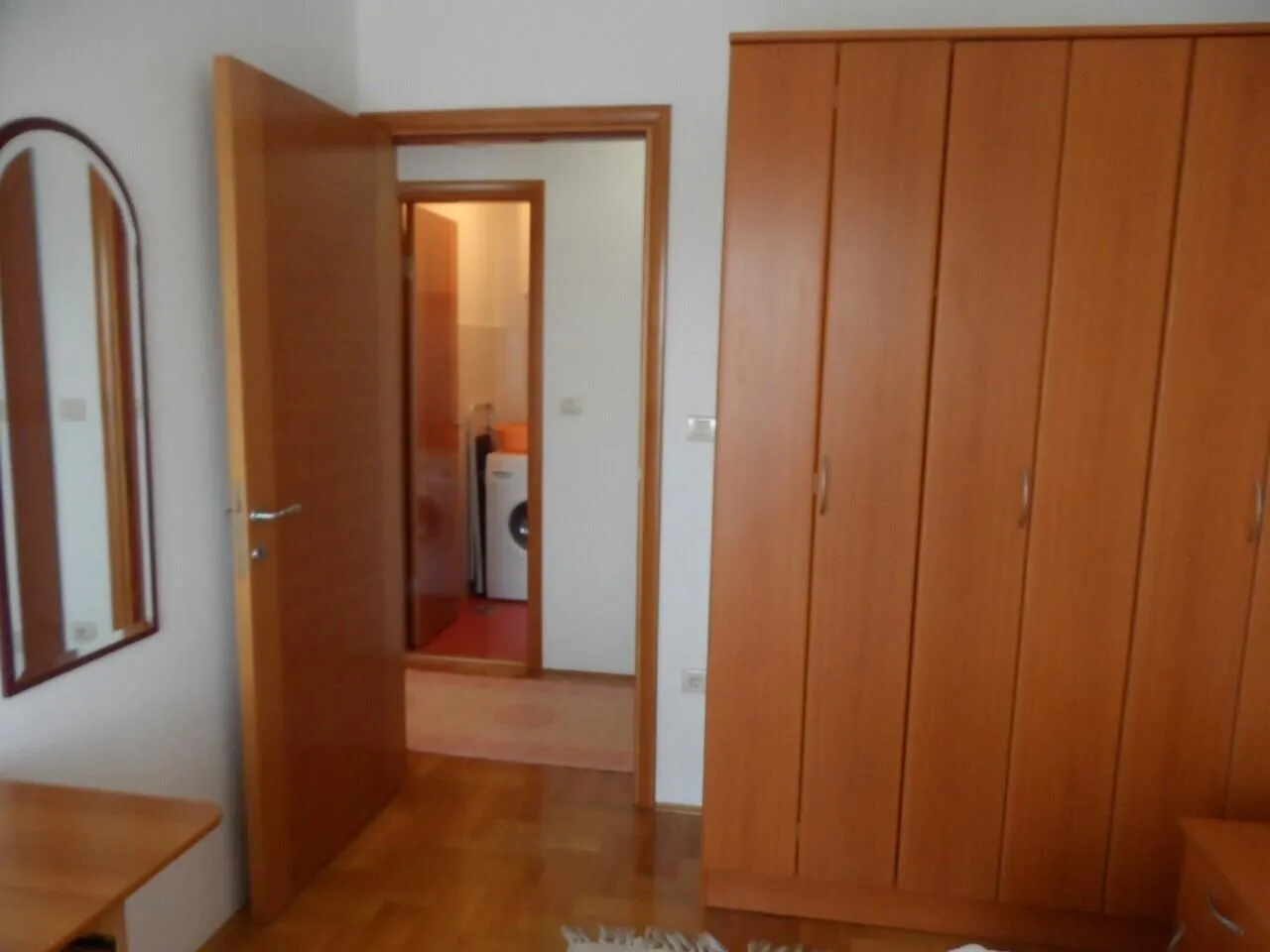 Soba sa drvenim ormarom i pogledom prema hodniku.