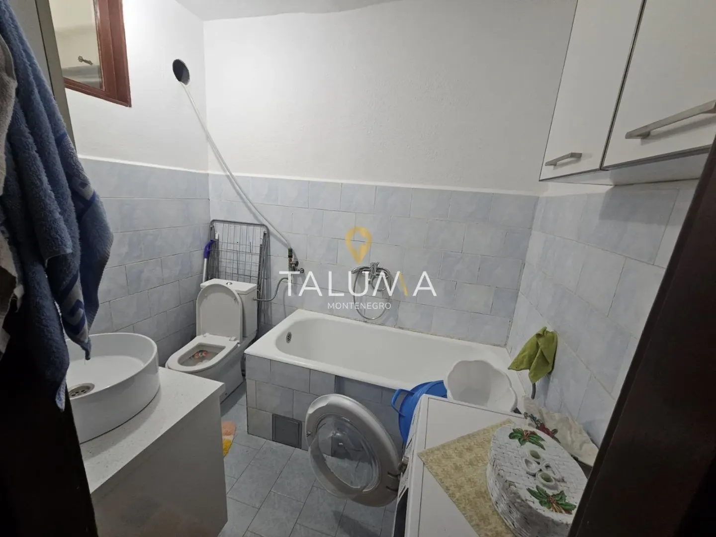 Bathroom with a bathtub, washbasin, toilet, and washing machine.