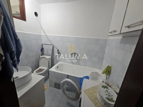 Bathroom with a bathtub, washbasin, toilet, and washing machine. - image 8