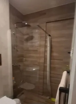 Moderne kupatilo sa tuš kabinom obloženom pločicama u dezenu drveta. - image 6