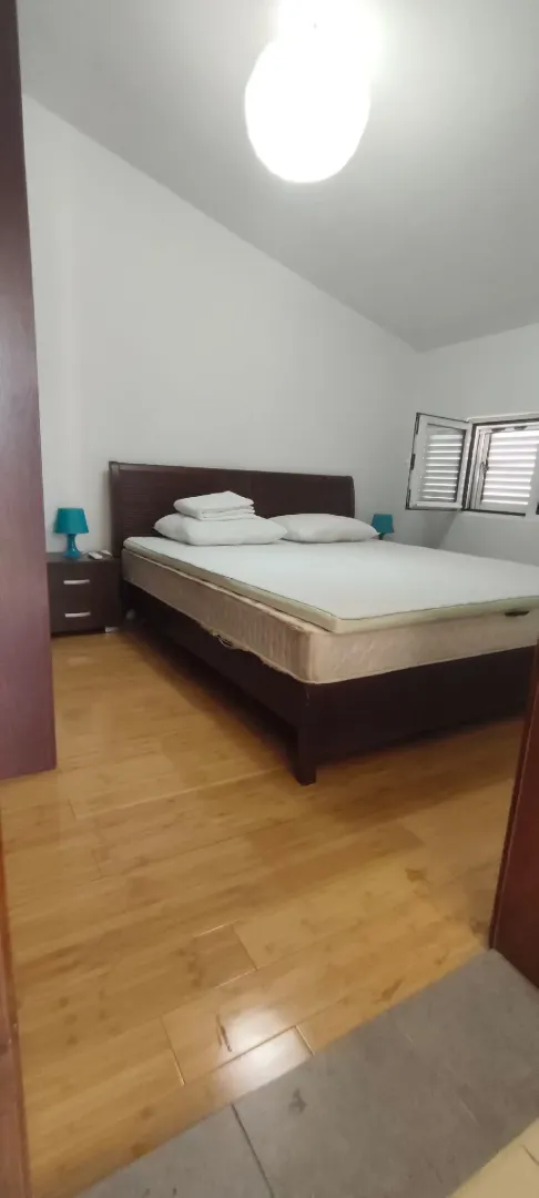Bedroom with a double bed, wooden flooring, and a window.