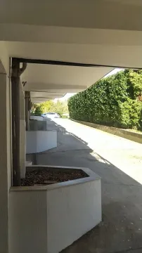 Covered parking space with an access road next to the building. - image 20
