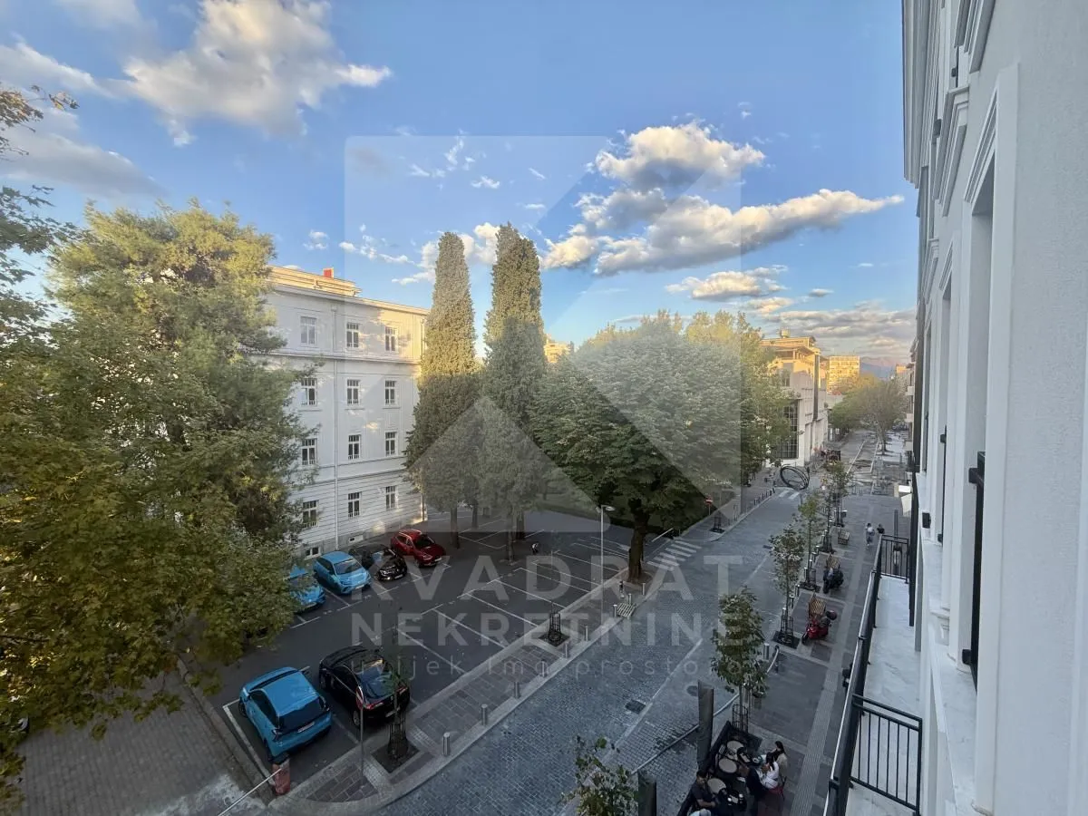 View from the terrace overlooking the city street and trees.