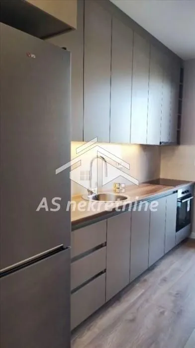 Modern kitchen with grey cabinets and built-in appliances.