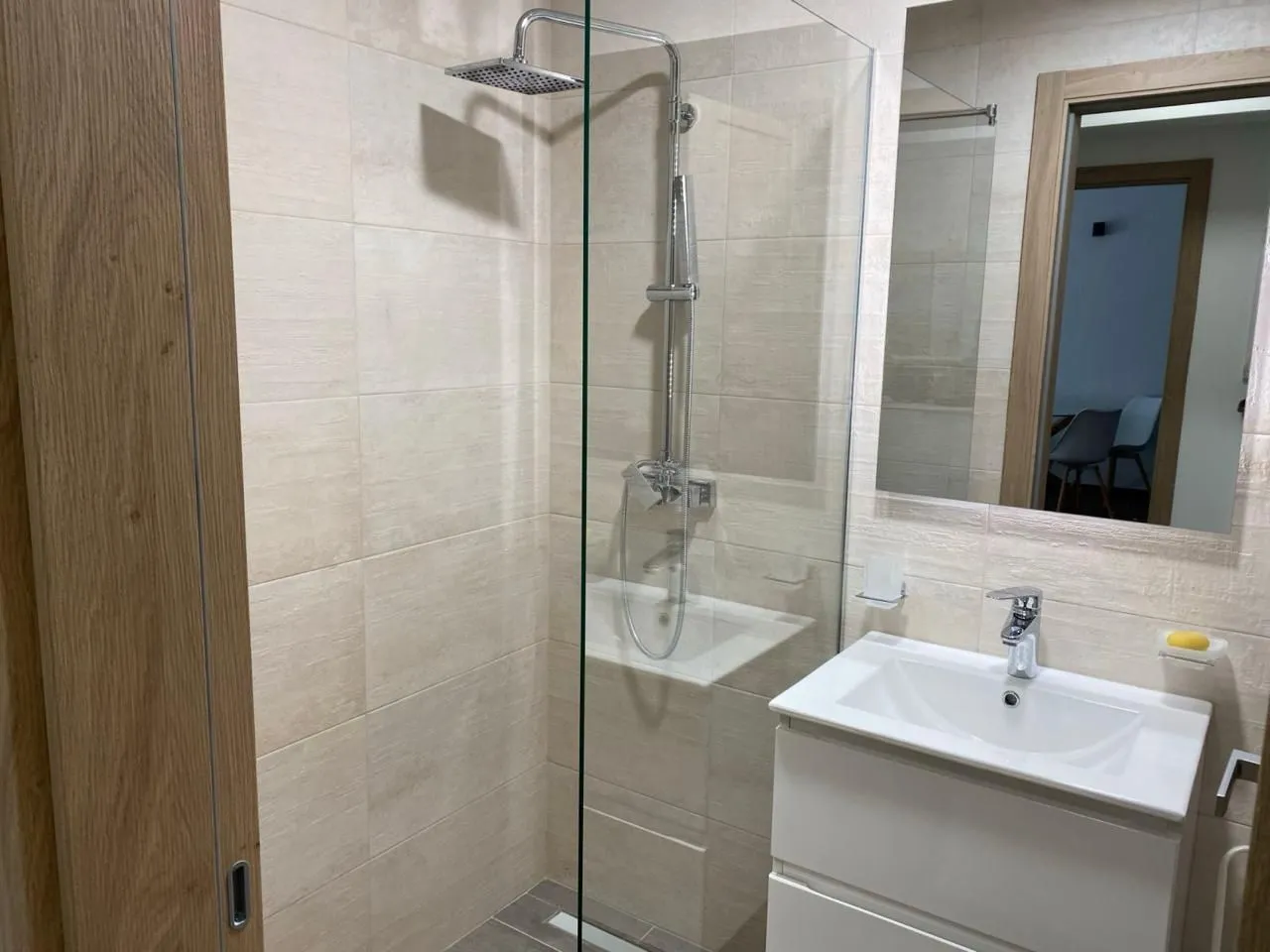 Modernly equipped bathroom with a walk-in shower and washbasin.
