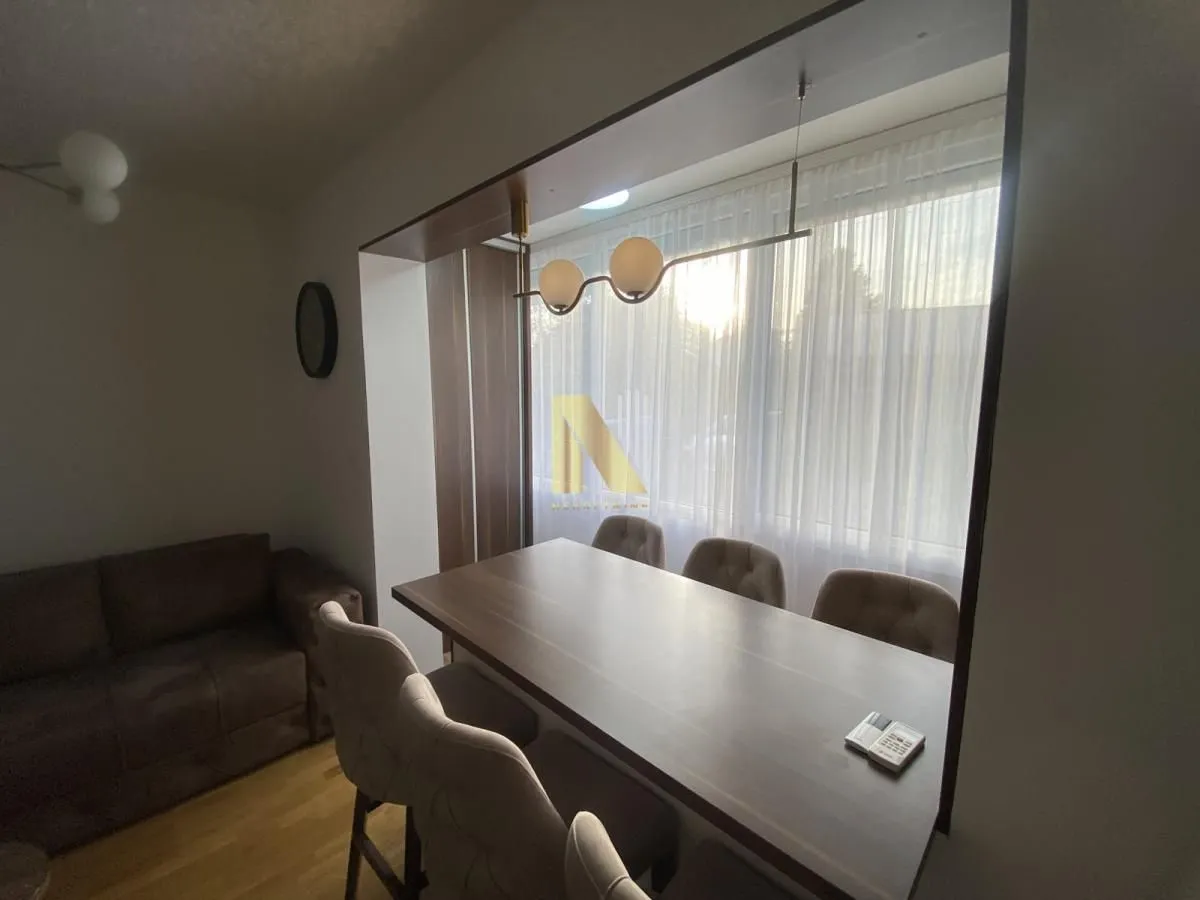 Living room with a dining area and a large window.