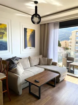 Living room with a sectional sofa, coffee table, and access to a terrace with a view. - image 8
