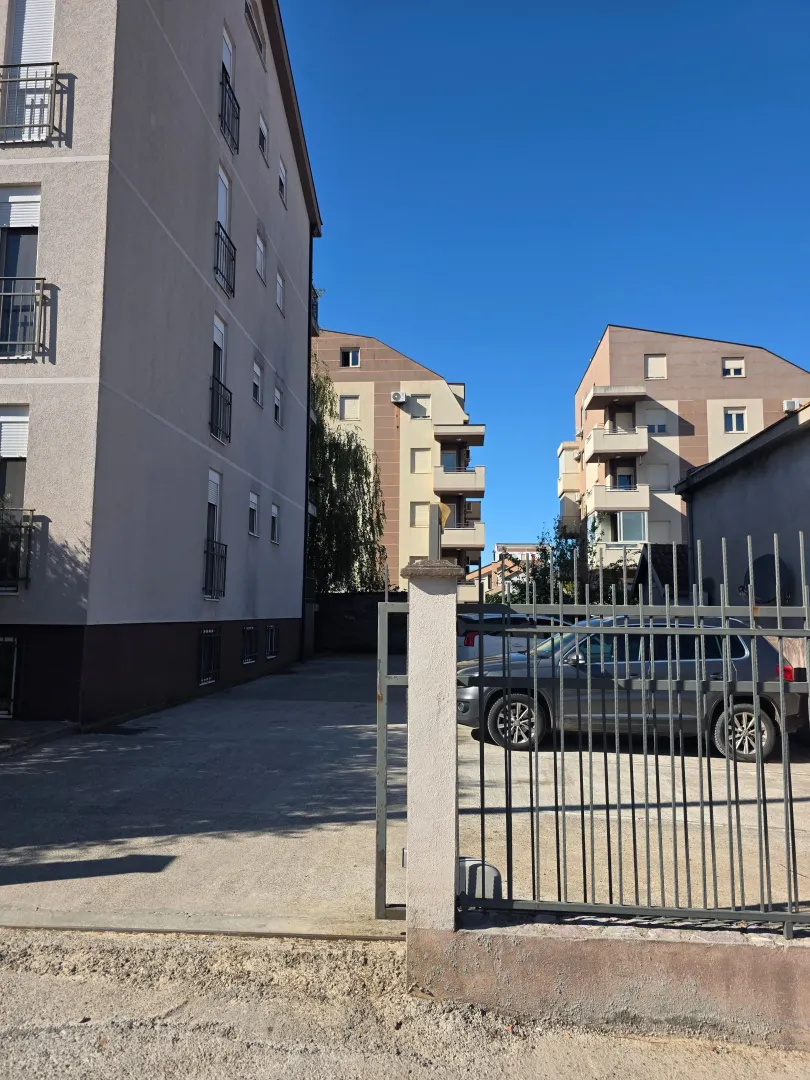 View of the courtyard and exterior of residential buildings with a fence.