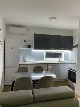 Modern kitchen with dark upper cabinets and white lower cabinets, featuring a dining table with chairs. - image 4