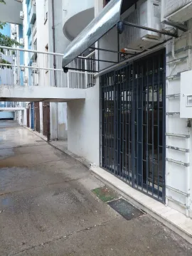 Entrance to a commercial space with metal grilles and a canopy on the building facade. - image 4