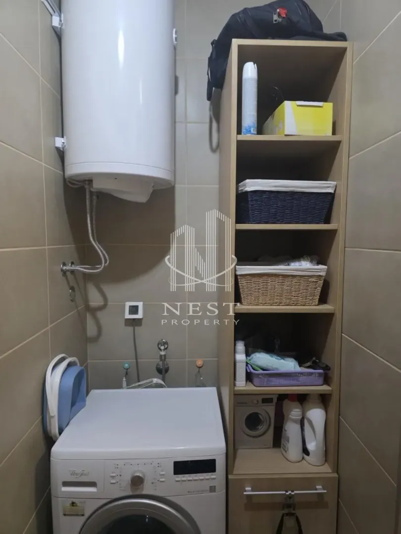Bathroom equipped with a washing machine, water heater, and storage shelves.