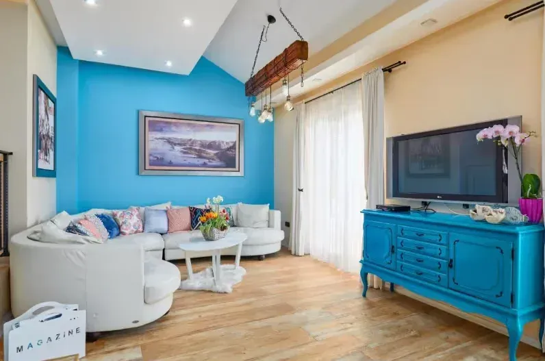 Living room with a white sectional sofa and a blue accent wall.