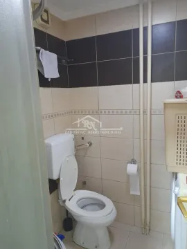 Bathroom with a toilet, tiles, and sanitary ware. - image 12