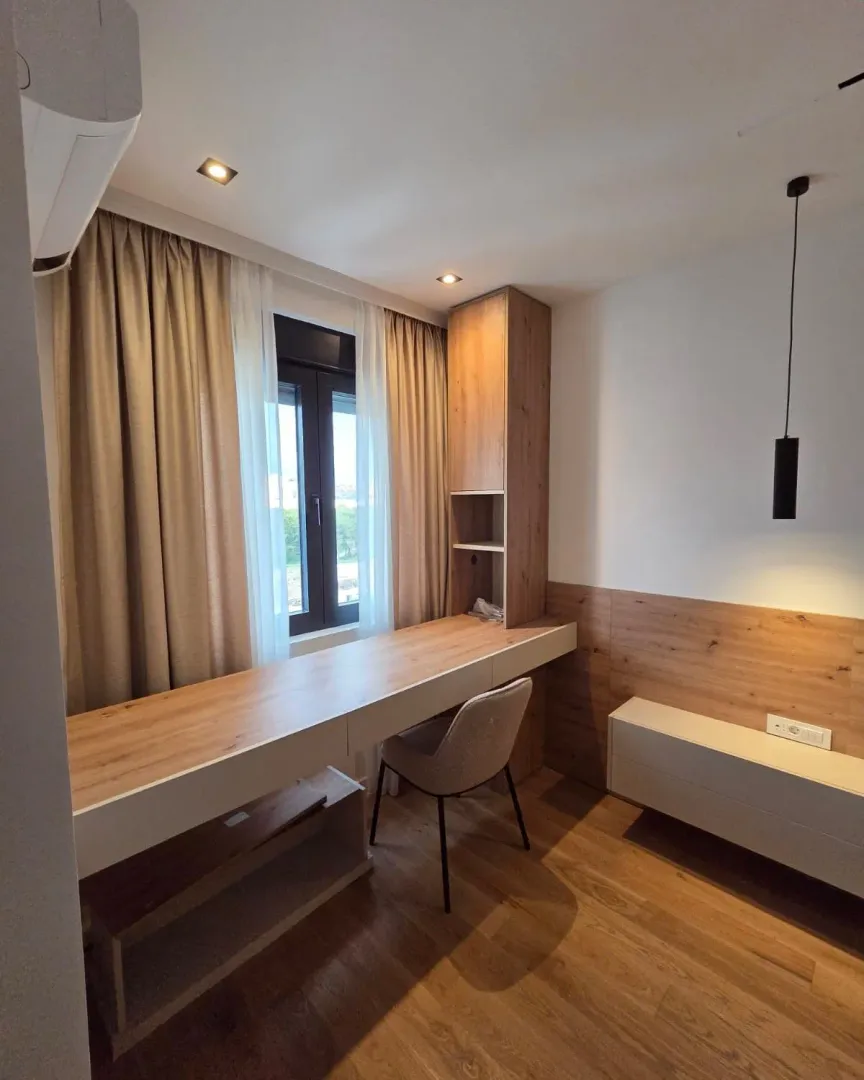 Modern bedroom with a desk and built-in furniture.