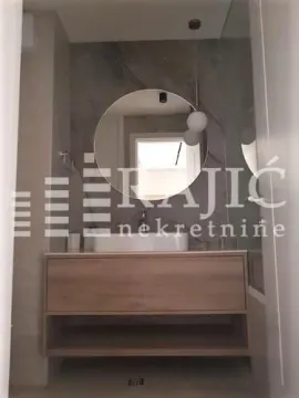 Modern bathroom with a washbasin and a large round mirror. - image 4