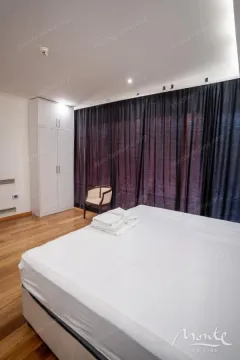 Bedroom with a large double bed, wardrobe, and dark curtains. - image 15