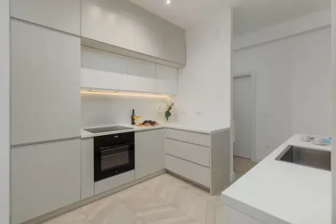 Modern kitchen with built-in cabinetry and white countertops. - image 3