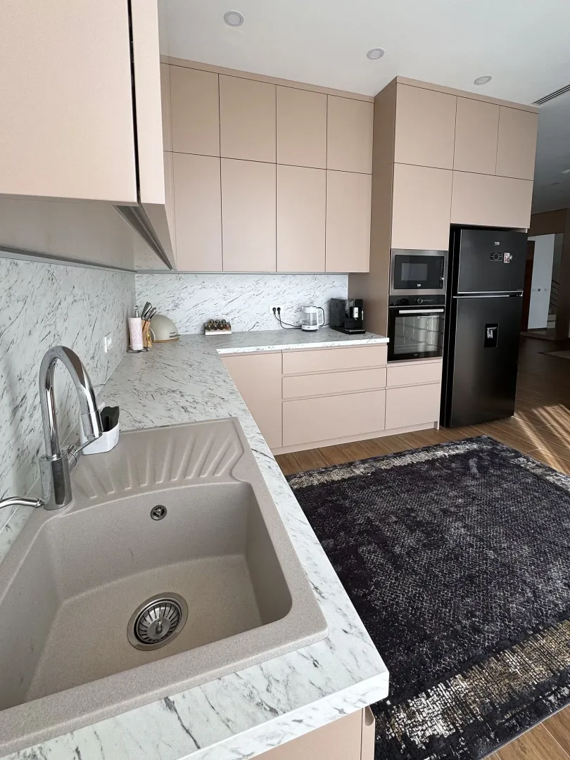 Kitchen with beige cabinets, marble countertops, and built-in appliances.