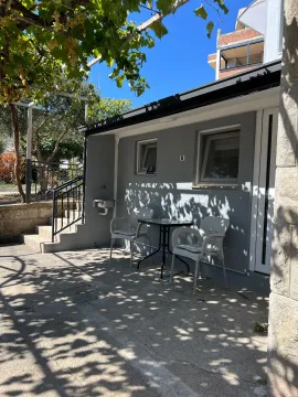 Paved courtyard with outdoor seating in front of the house. - image 14