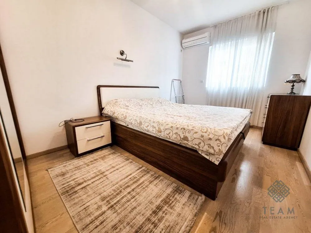 Furnished bedroom with a double bed, nightstand, and wardrobe.