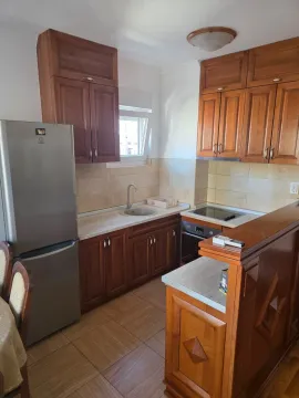 Kitchen with wooden cabinetry, a refrigerator, and a breakfast bar. - image 3