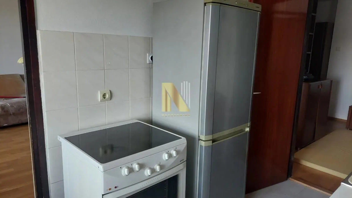 Small kitchen with a stove and a refrigerator.
