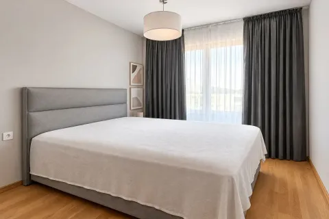 Moderna spavaća soba sa velikim bračnim krevetom, sivim zavjesama i parketom. - image 7