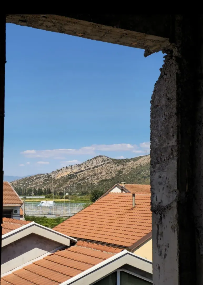 Pogled na okolna brda i krovove iz prostorije u izgradnji.
