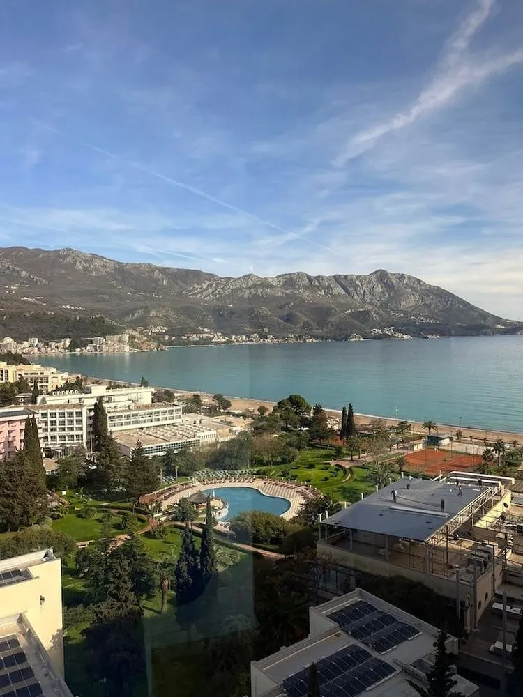 View from the window overlooking the sea, coast, and mountains in the background.