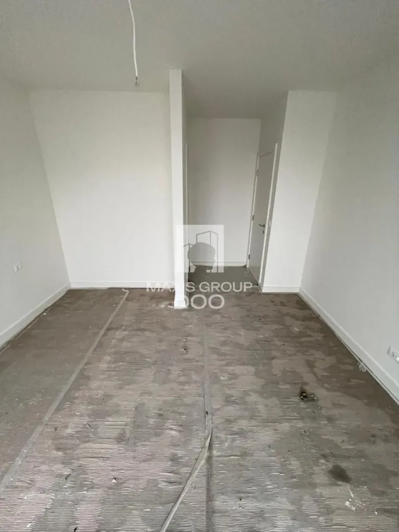 Empty unfinished room with white walls and a floor prepared for installation of flooring.
