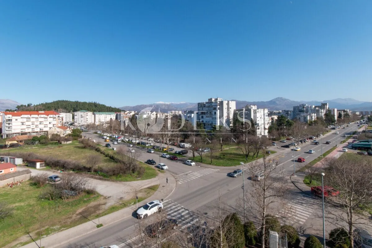 Pogled iz stana na gradsku ulicu i okolne zgrade.